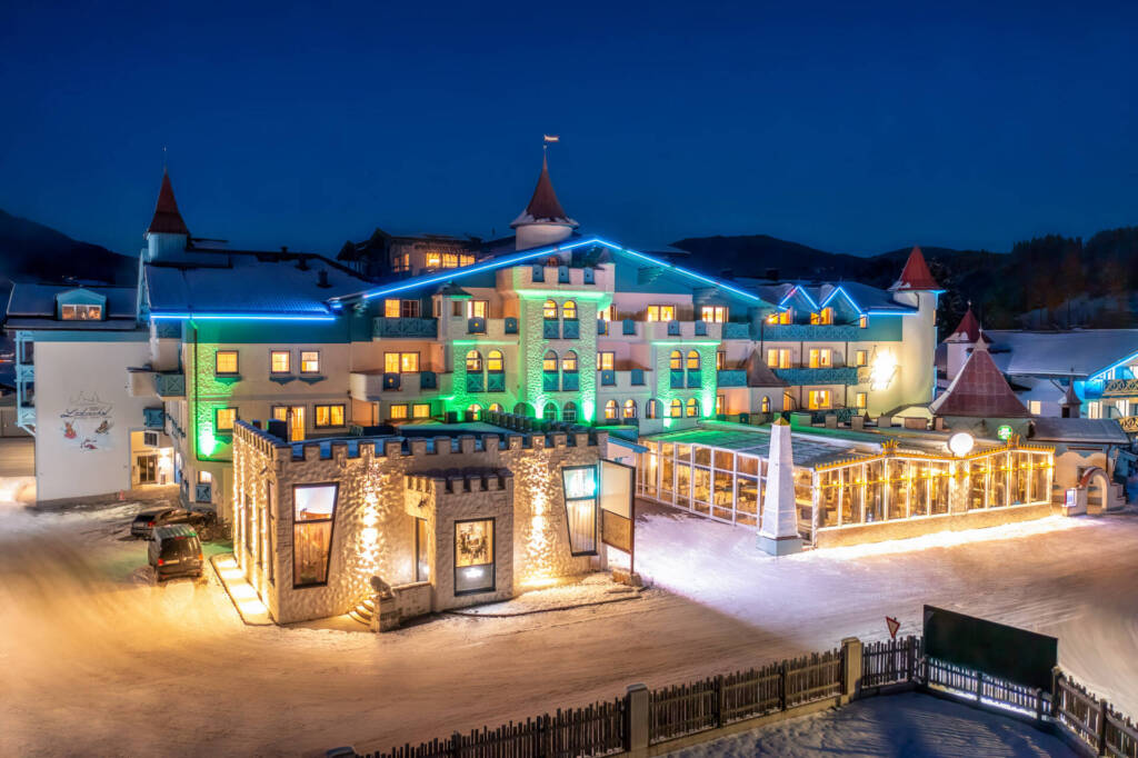 Nachtaufnahme des Schlosshotels Lacknerhof direkt an den Pisten des Flachauer Skigebiets